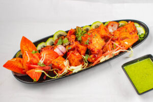 "Traditional Indian thali with a variety of curries, rice, and bread served on a metal plate"